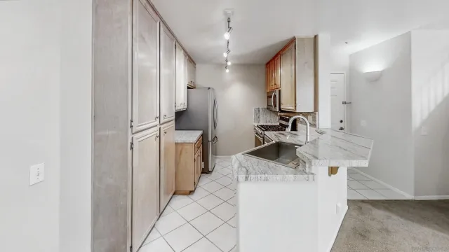 a kitchen with stainless steel appliances kitchen island a sink stove and refrigerator