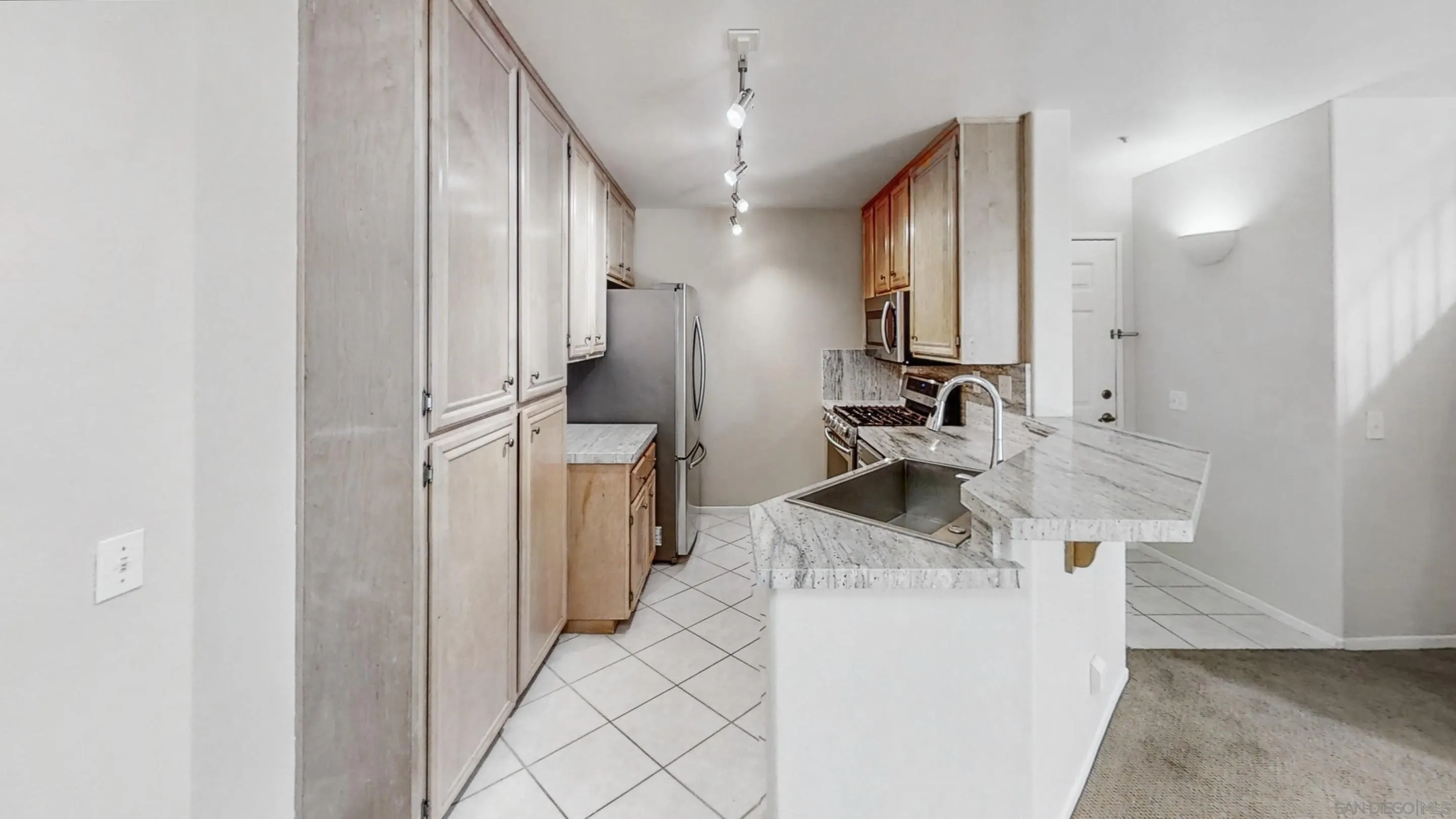 11175 Affinity Court, Unit 45 San Diego, CA 92131 - Photo 10 of 36 a kitchen with stainless steel appliances kitchen island a sink stove and refrigerator