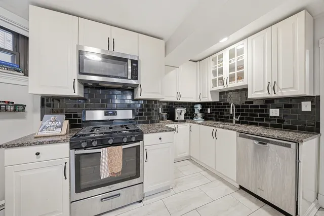 a kitchen with stainless steel appliances granite countertop a stove a sink and a refrigerator