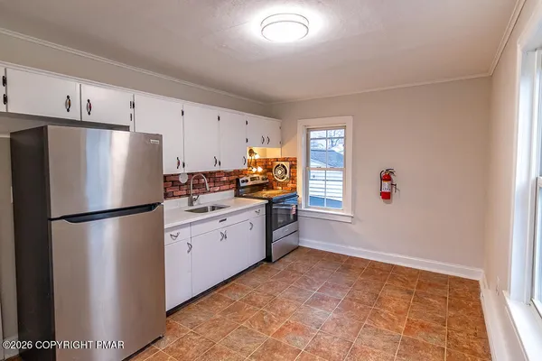 a kitchen with stainless steel appliances a refrigerator sink and cabinets