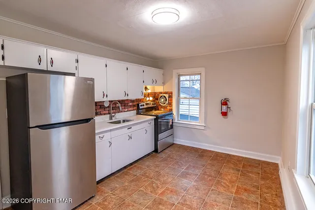 a kitchen with stainless steel appliances a refrigerator sink and cabinets