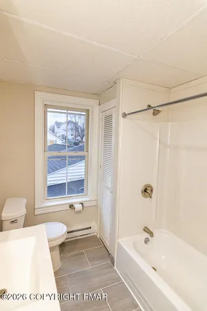 a bathroom with a bathtub a shower a toilet and a sink