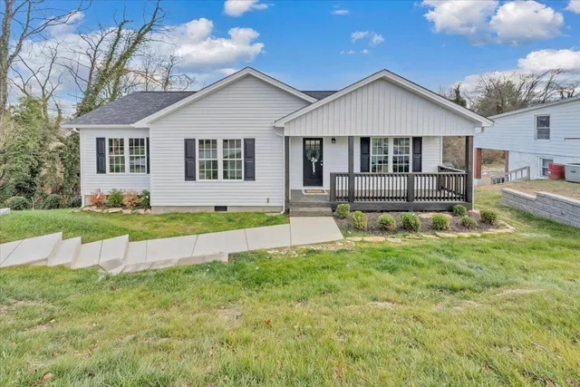 a front view of a house with a yard outdoor seating and garage
