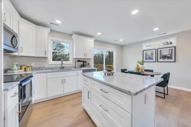 a kitchen with granite countertop white cabinets and white appliances