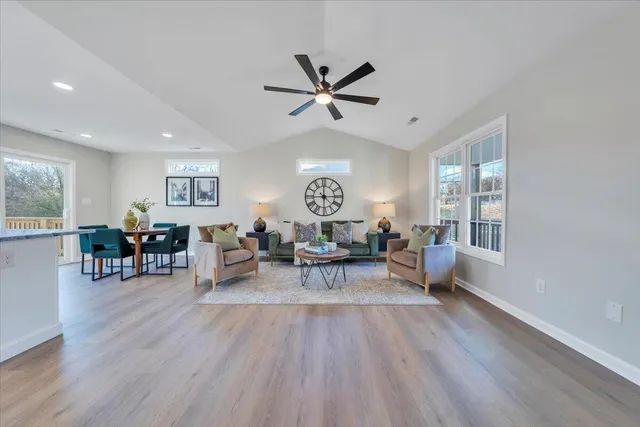 a living room with furniture a window and wooden floor