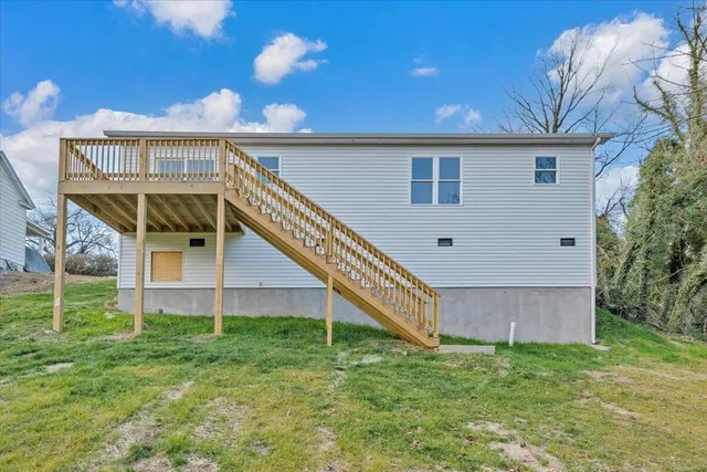 a view of a big house with a big yard and large trees