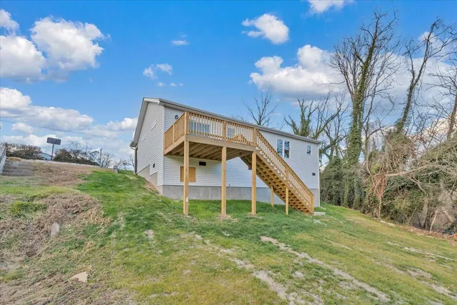 a view of a big house with a big yard and large trees