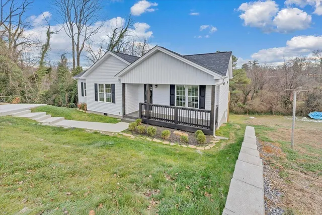 a view of a house with a small yard and wooden fence