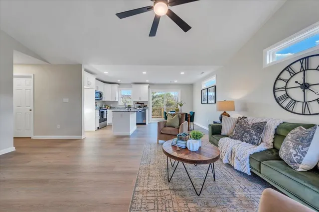 a living room with furniture and a view of kitchen