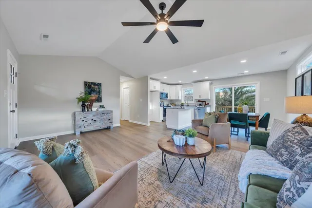 a living room with furniture and a dining table with kitchen view