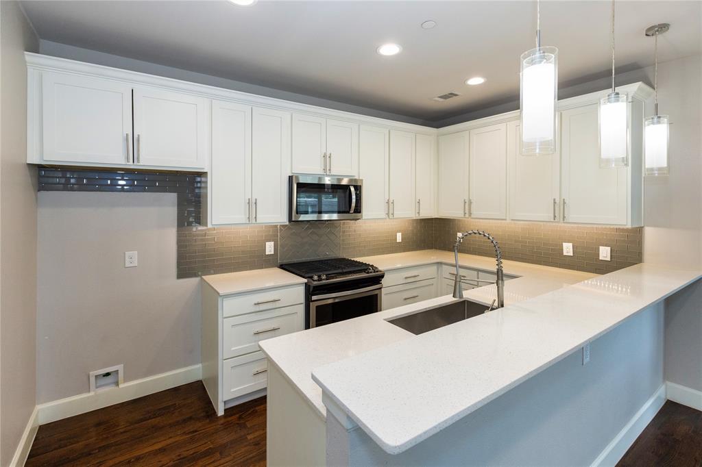 2016 North Fitzhugh Avenue, Unit 101 Dallas, TX 75204 - Photo 9 of 26 Kitchen with white cabinetry, stainless steel appliances, tasteful backsplash, a peninsula, and recessed lighting