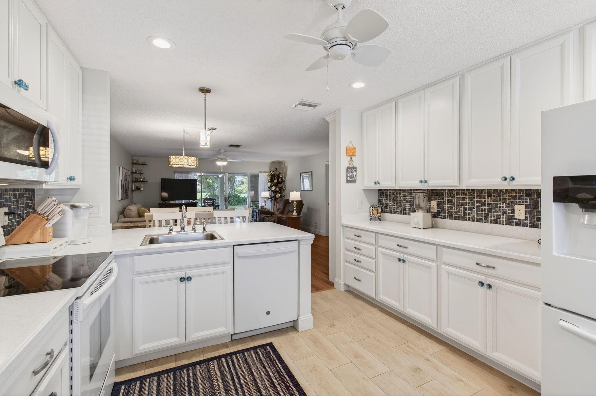5452 Poppy Place, Unit D Delray Beach, FL 33484 - Photo 8 of 62 a kitchen with stainless steel appliances kitchen island granite countertop a sink and cabinets