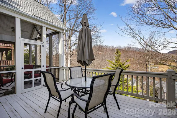 a balcony with wooden floor table and chairs