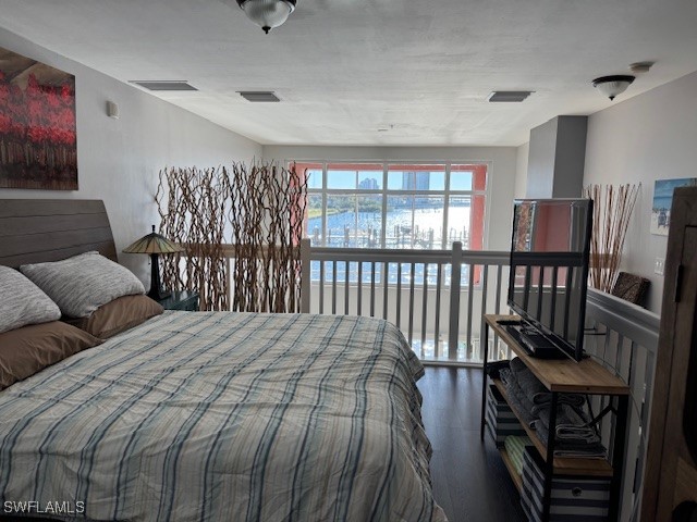 2743 First Street, Unit 105 Fort Myers, FL 33916 - Photo 17 of 29 a bedroom with a bed a flat screen tv and a large window
