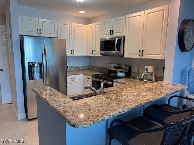 2743 First Street, Unit 105 Fort Myers, FL 33916 - Photo 4 of 29 a kitchen with kitchen island granite countertop a stove oven and a refrigerator