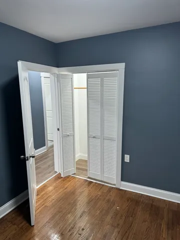 an empty room with wooden floor and mirror