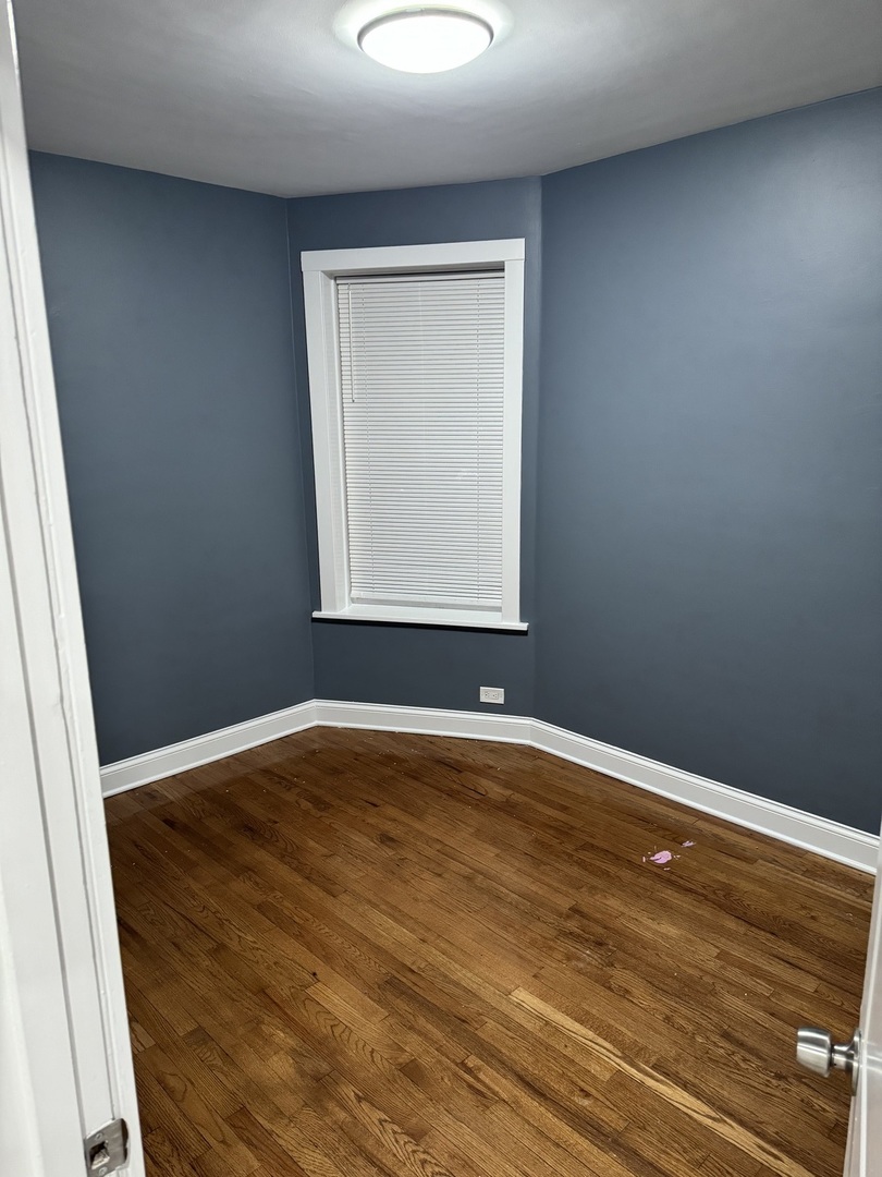 1250 North Monitor Avenue Chicago, IL 60651 - Photo 12 of 28 an empty room with wooden floor and windows
