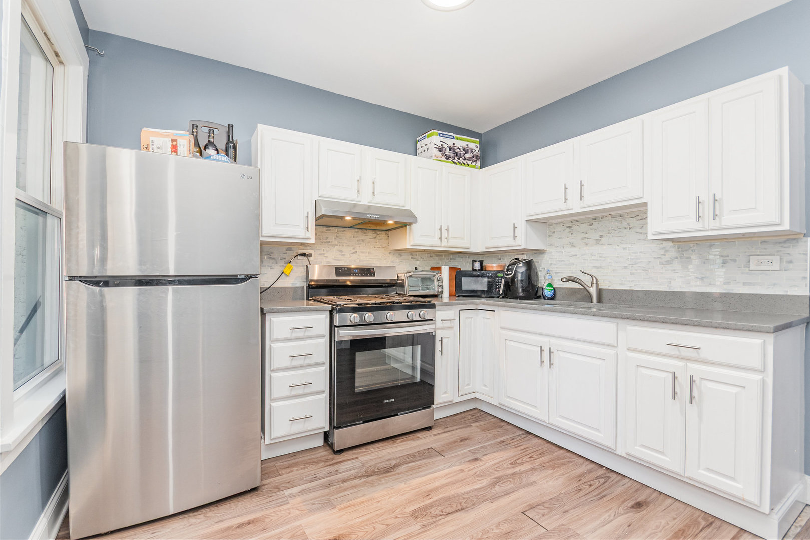 1250 North Monitor Avenue Chicago, IL 60651 - Photo 2 of 28 a kitchen with stainless steel appliances a refrigerator sink and cabinets