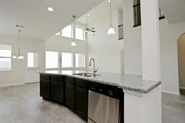a kitchen with granite countertop a sink cabinets and window