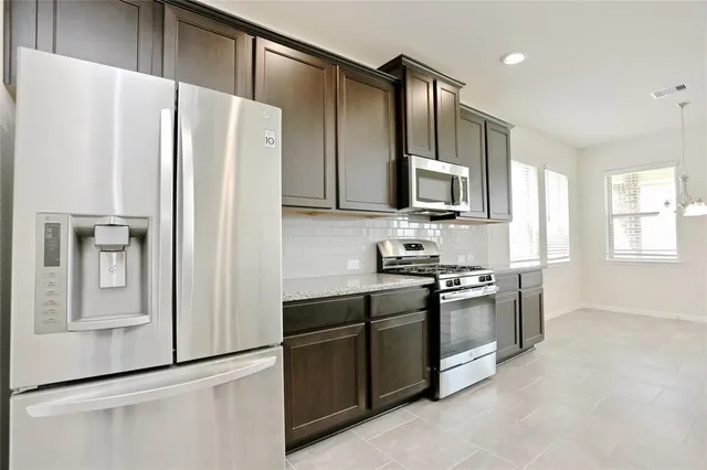 a kitchen with stainless steel appliances granite countertop a refrigerator stove and microwave