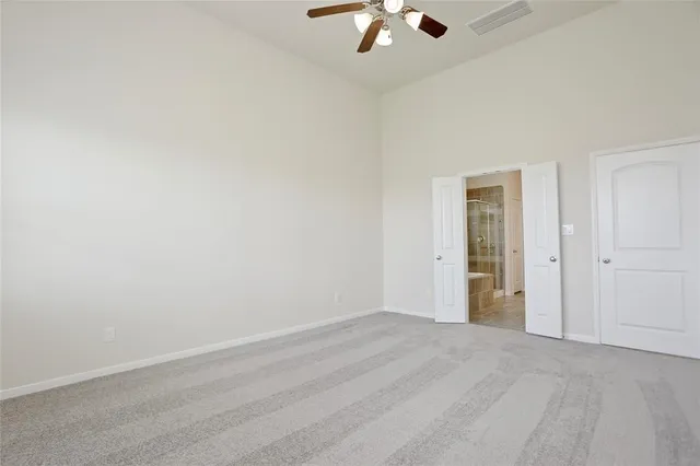 an empty room with a chandelier fan