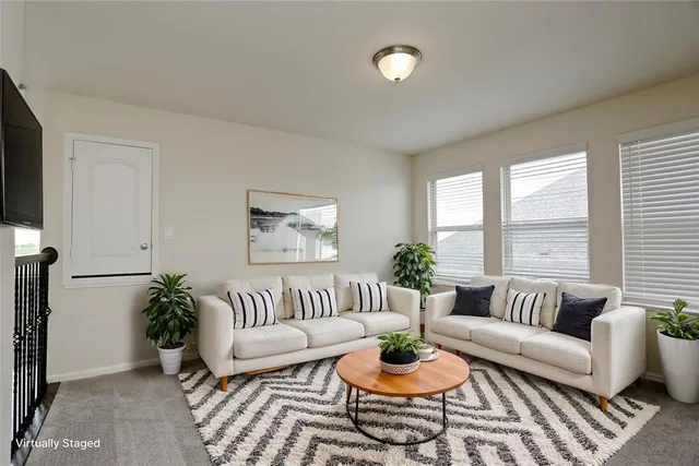 a living room with furniture potted plant and window