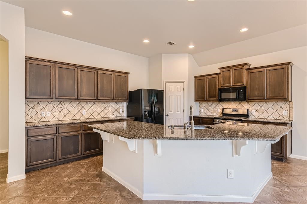290 Maeves Way Austin, TX 78737 - Photo 5 of 13 Culinary creations come to life in this kitchen, boasting rich wood cabinetry and an inviting island.