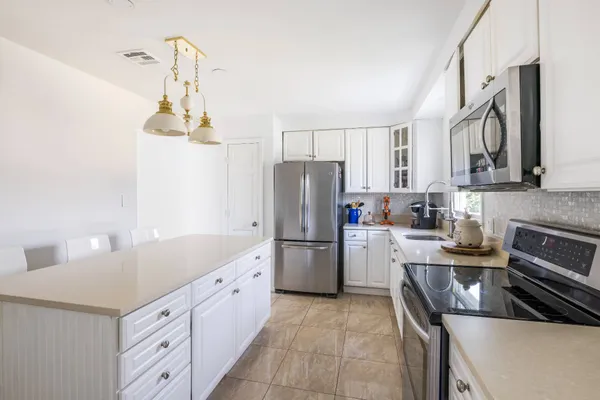 a kitchen that has a refrigerator a stove and a sink