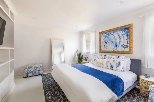 a bedroom with a bed and a painting on the wall