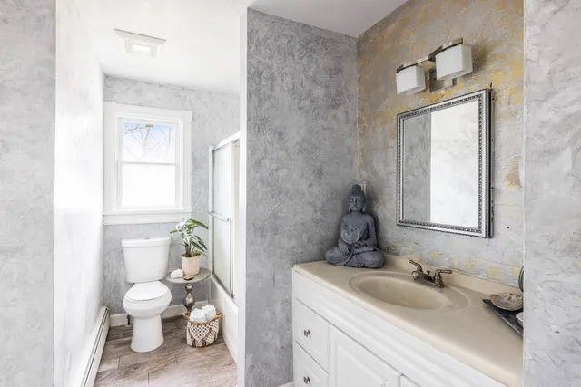 a bathroom with a toilet a sink and mirror