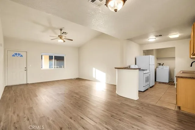 a view of a kitchen with furniture and wooden floor
