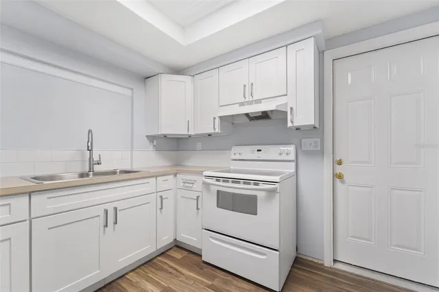 a kitchen with white cabinets and white appliances