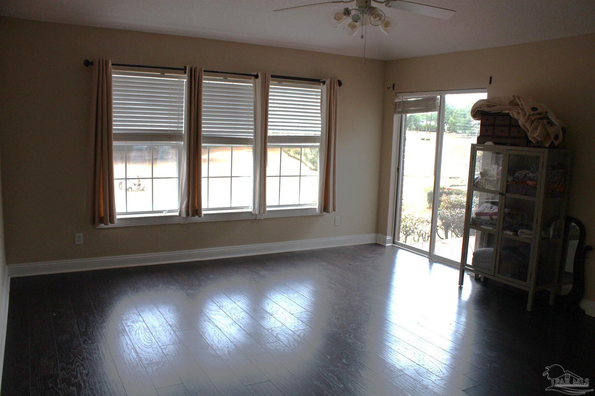 5708 Tamarack Drive Pace, FL 32571 - Photo 11 of 29 an empty room with wooden floor and windows