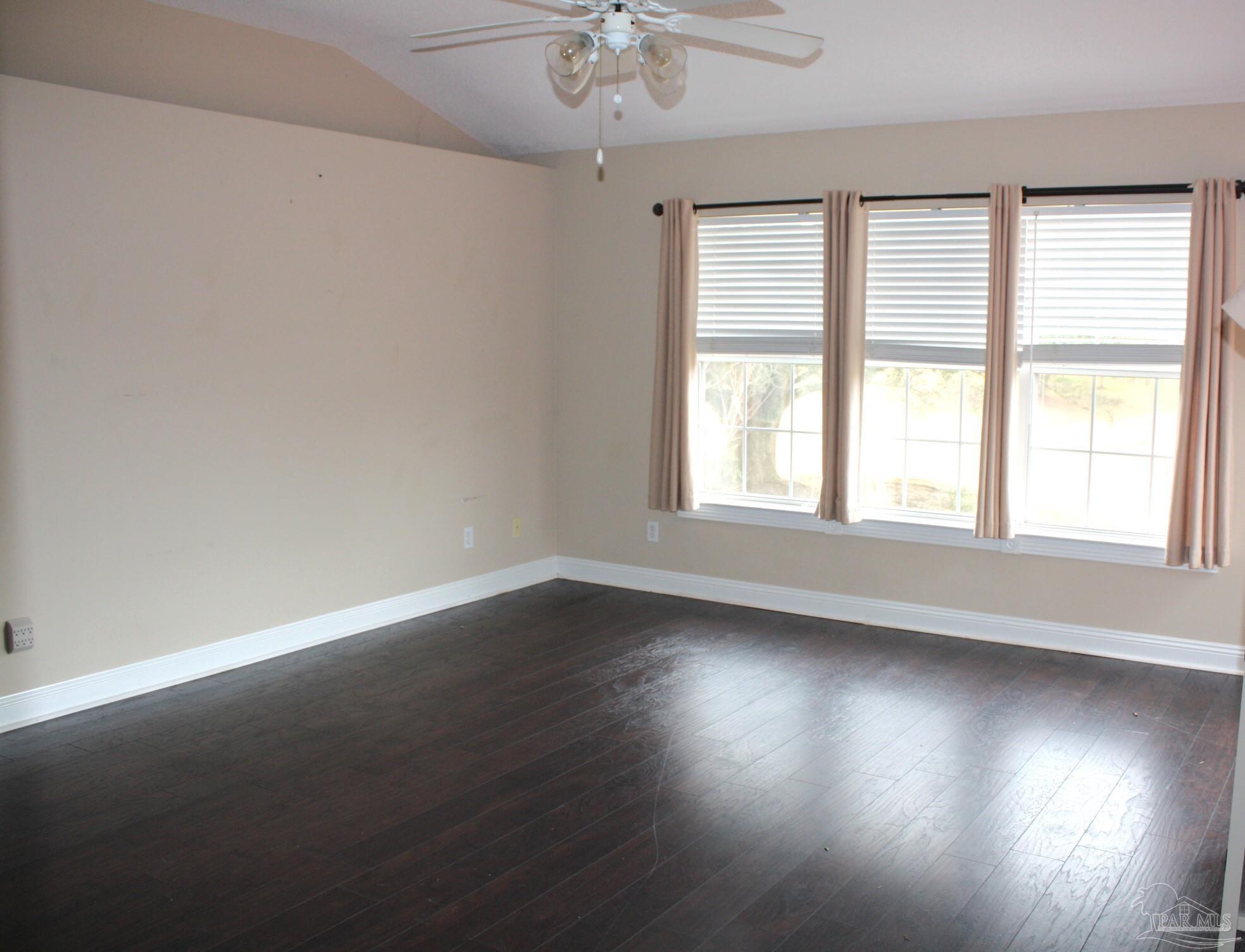 5708 Tamarack Drive Pace, FL 32571 - Photo 12 of 29 an empty room with wooden floor and windows