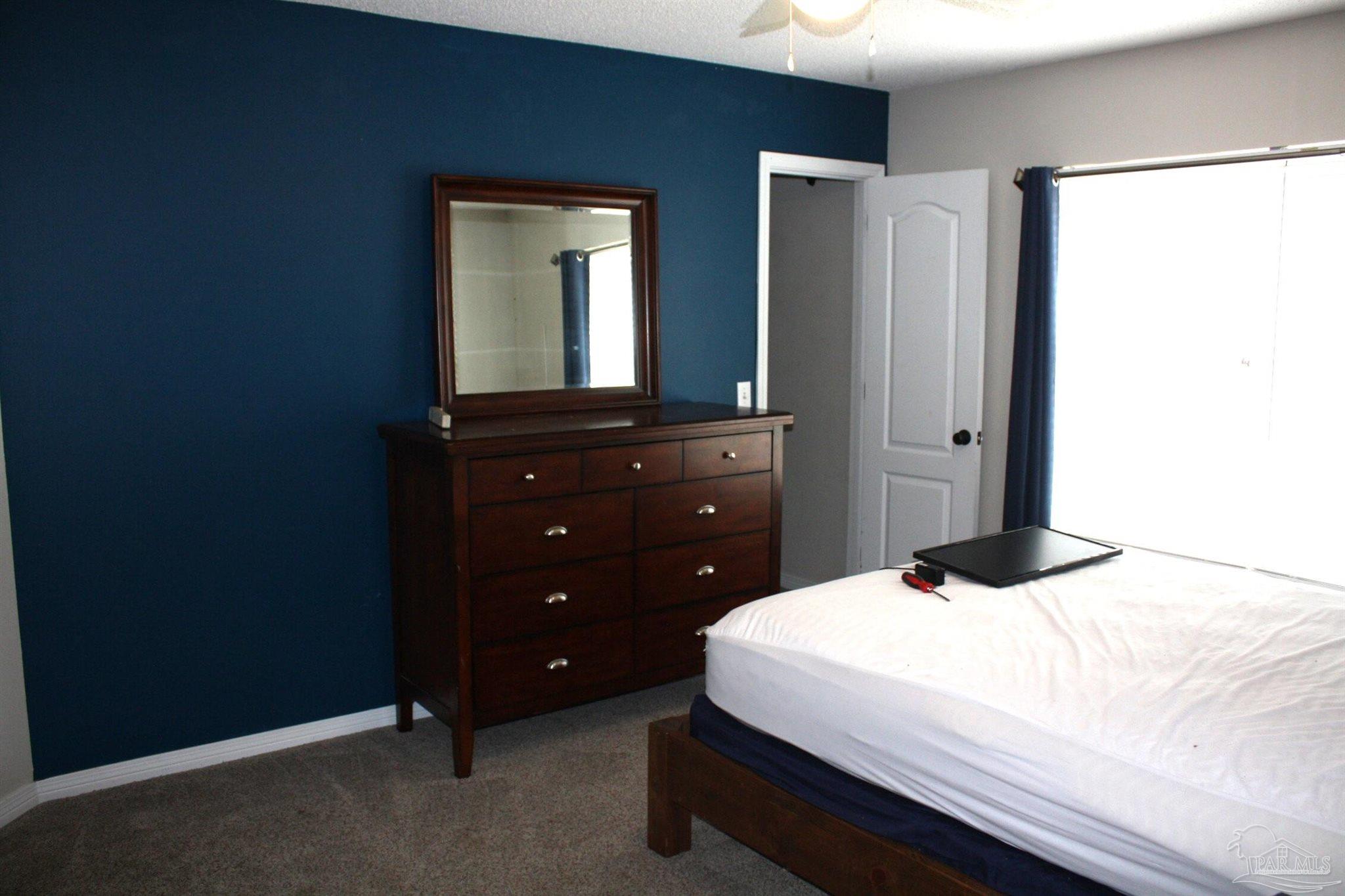 5708 Tamarack Drive Pace, FL 32571 - Photo 14 of 29 a bedroom with a bed and a dresser