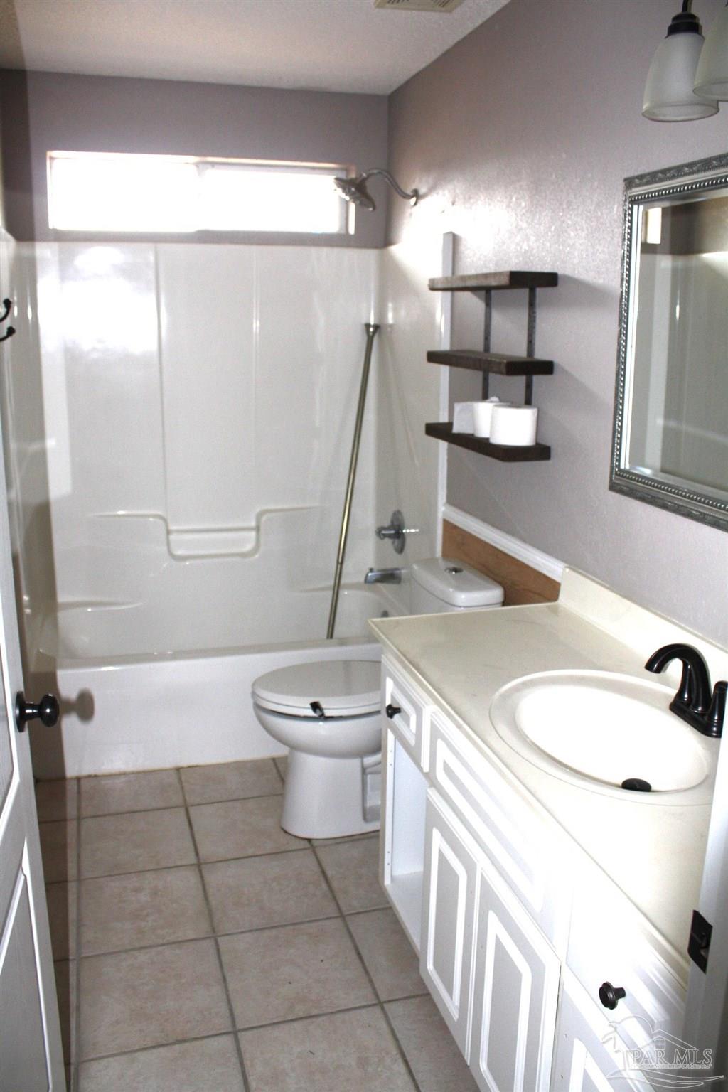 5708 Tamarack Drive Pace, FL 32571 - Photo 15 of 29 a bathroom with a sink a toilet and a mirror