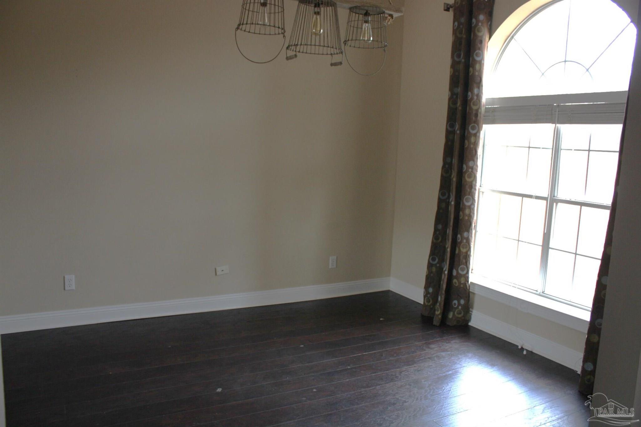5708 Tamarack Drive Pace, FL 32571 - Photo 16 of 29 an empty room with wooden floor and windows