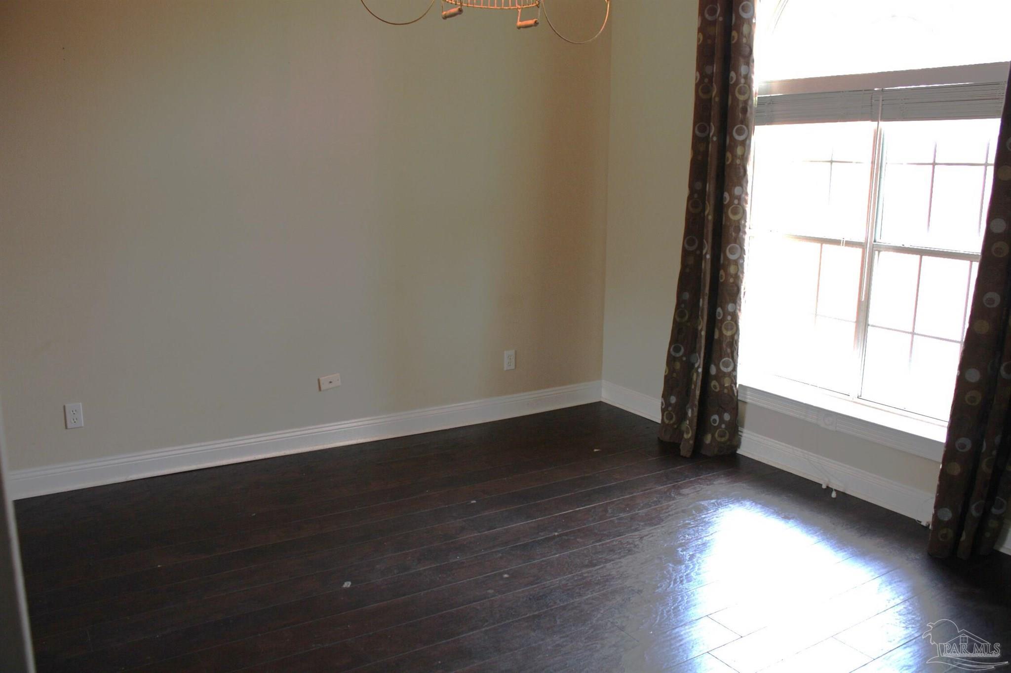 5708 Tamarack Drive Pace, FL 32571 - Photo 17 of 29 a view of an empty room with wooden floor and a window