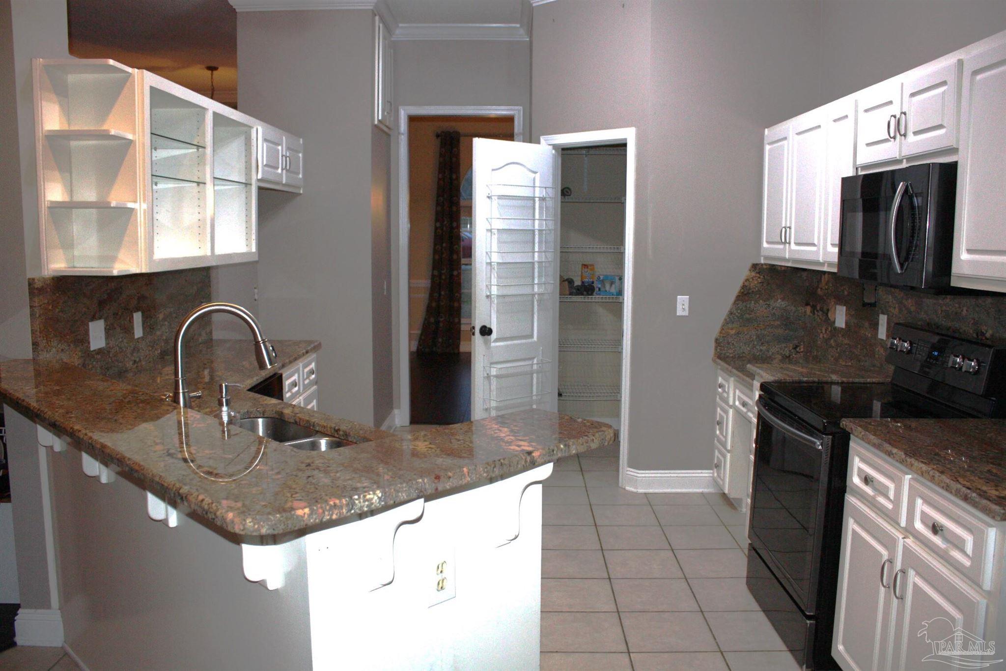 5708 Tamarack Drive Pace, FL 32571 - Photo 24 of 29 a kitchen with stainless steel appliances granite countertop a sink stove and refrigerator
