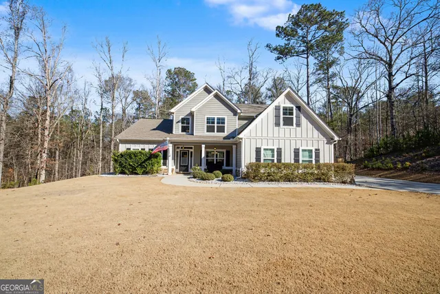 a front view of a house with a yard and trees