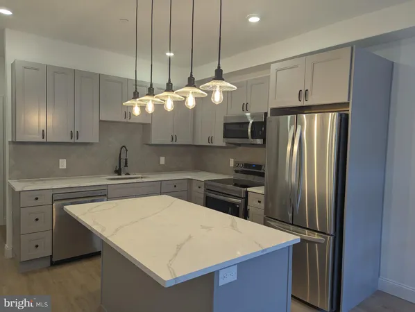a kitchen with a refrigerator a sink a stove and cabinets