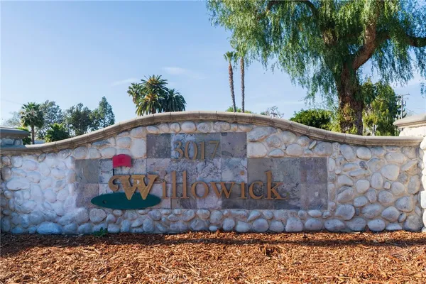 a view of a small house with a small yard and a large trees