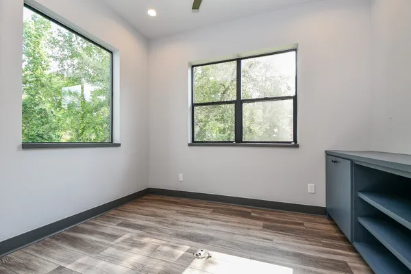 a view of empty room with window and wooden floor