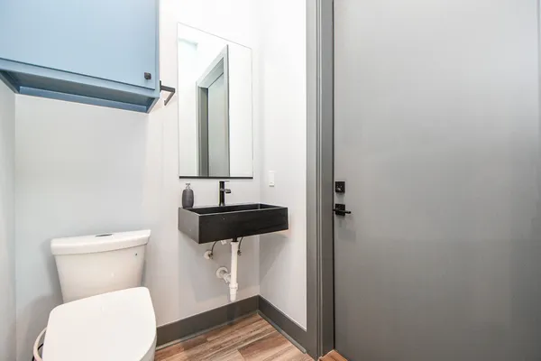 a bathroom with a toilet a sink and a mirror