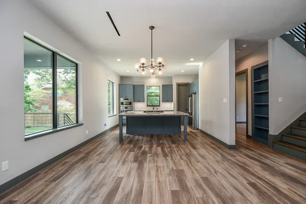 a view of a room with wooden floor staircase and a kitchen