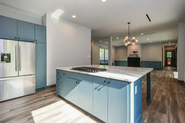 a kitchen with kitchen island a sink stove and refrigerator