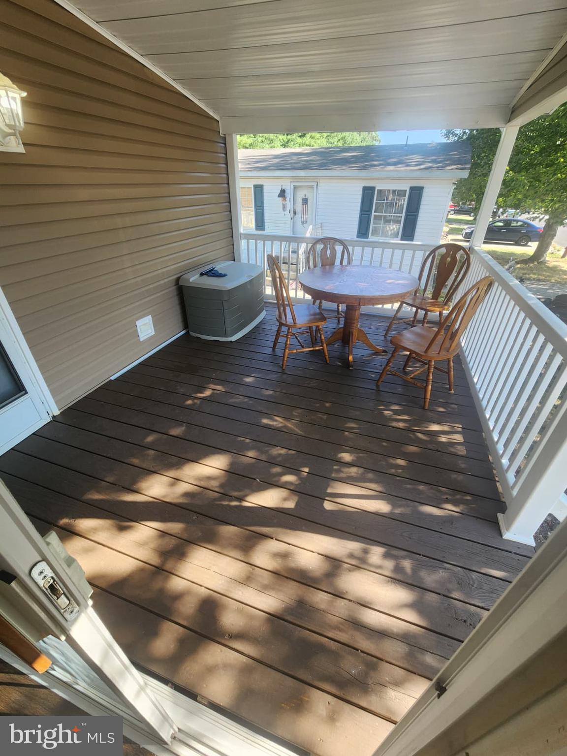 2110 Mays Landing Road, Unit 199 Millville, NJ 08332 - Photo 6 of 18 a view of a patio with table and chairs and wooden floor