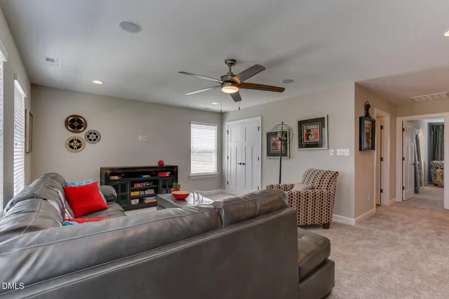 a living room with furniture and a ceiling fan