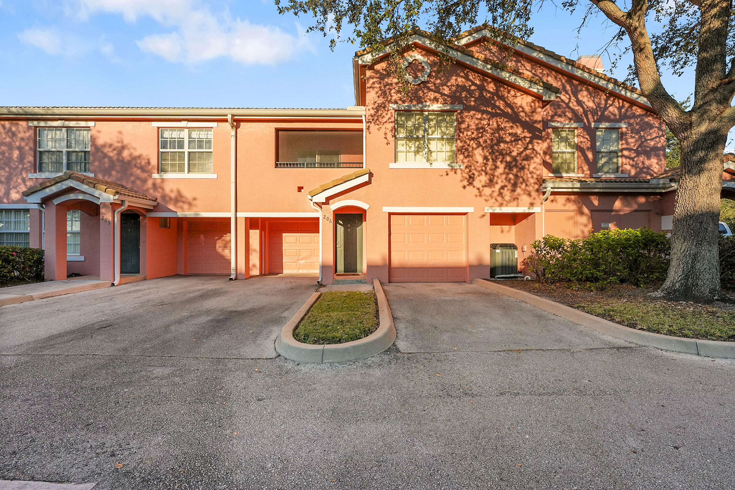 162 Southwest Peacock Boulevard, Unit 32206 Port St. Lucie, FL 34986 - Photo 1 of 24 a front view of a house with a yard and garage
