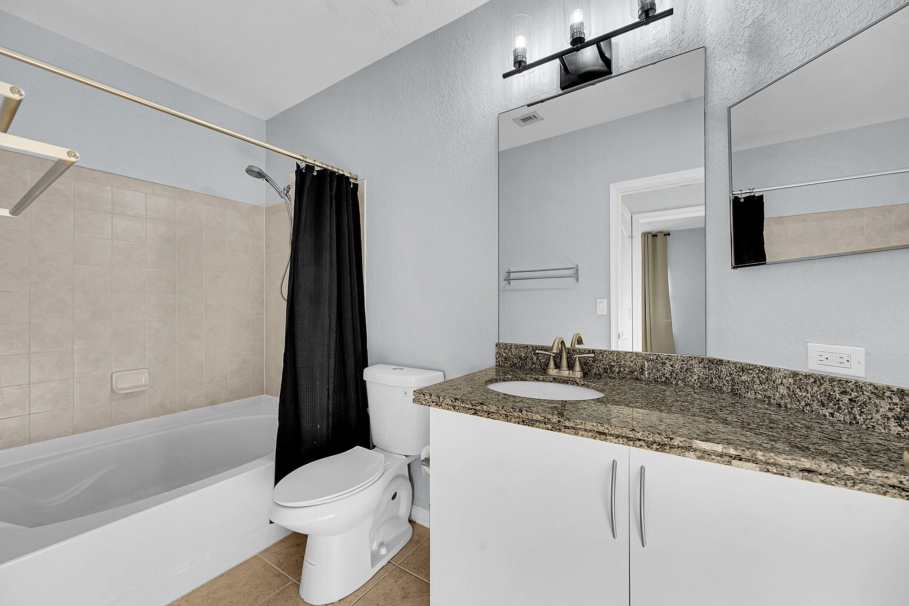 162 Southwest Peacock Boulevard, Unit 32206 Port St. Lucie, FL 34986 - Photo 11 of 24 a bathroom with a granite countertop sink toilet and shower